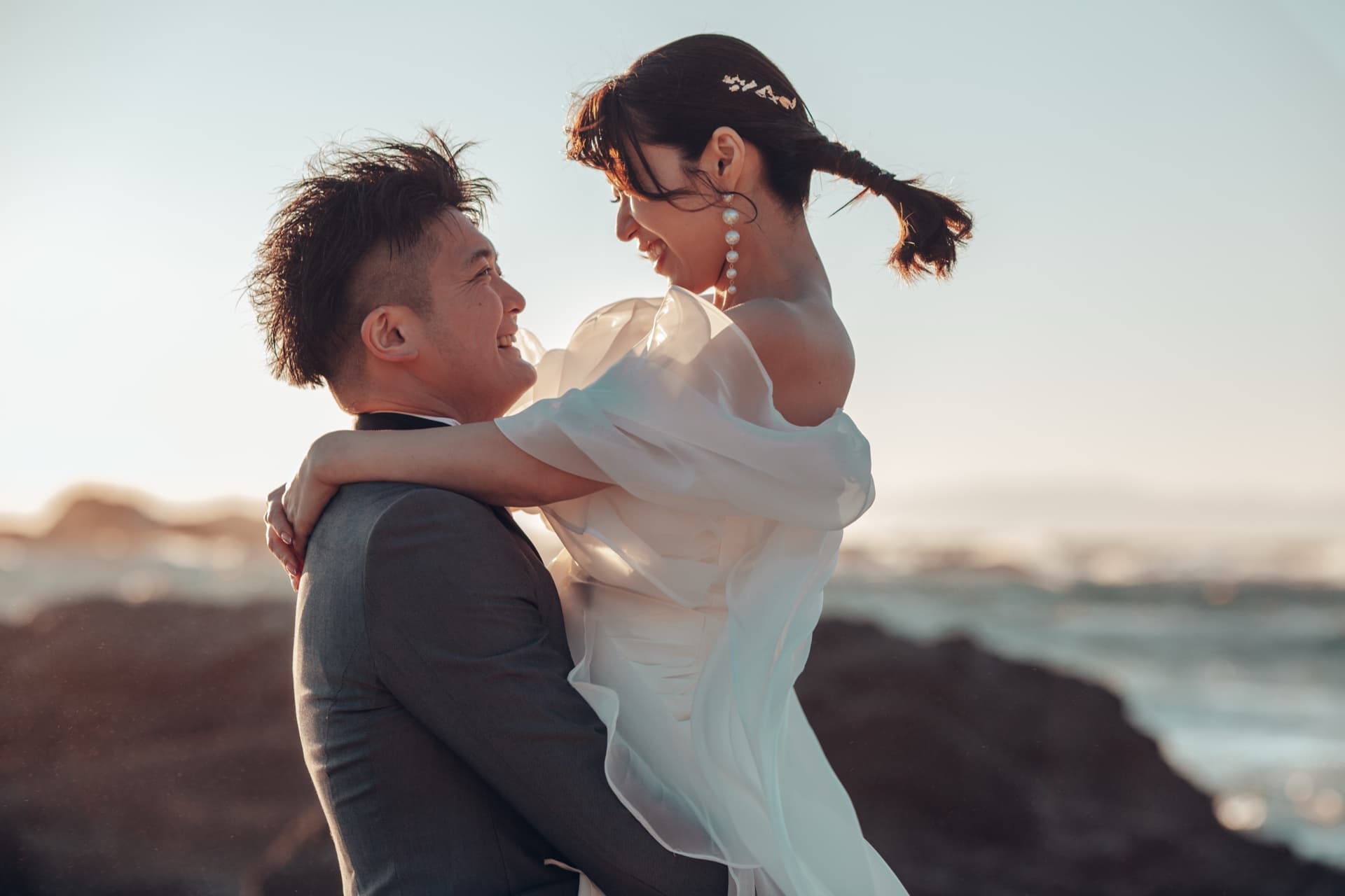 夕暮れの海岸で抱き合うふたり
